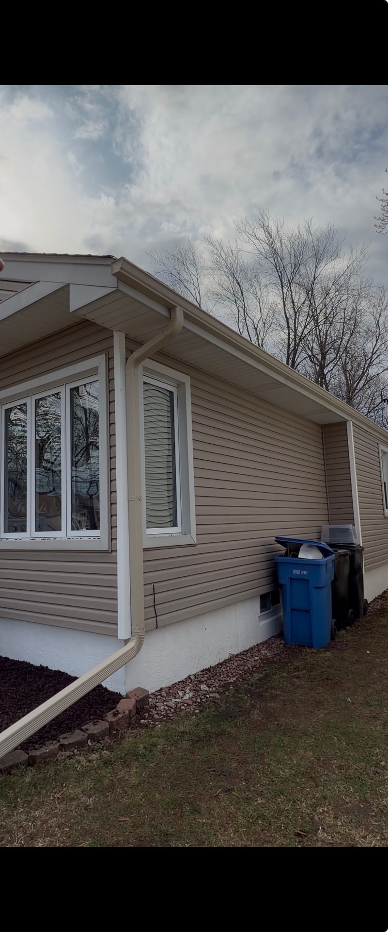 House gutter and downspout before and after a new gutter installation with extra downspouts (After)